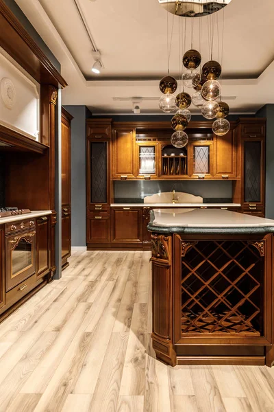 Elegante cocina con gran encimera de madera y lámpara de araña - foto de stock