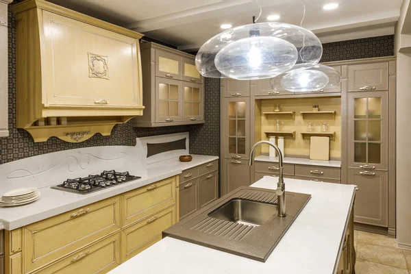 Elegante cocina con lámpara de araña sobre fregadero moderno - foto de stock