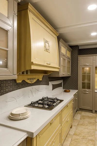 Interior of modern kitchen with plates on counter by stove — Stock Photo