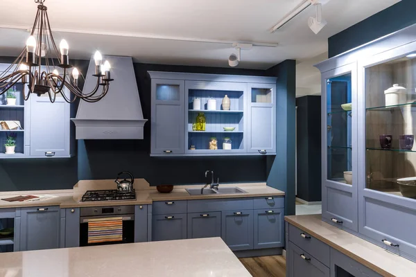 Stylish kitchen in blue tones with elegant chandelier — Stock Photo