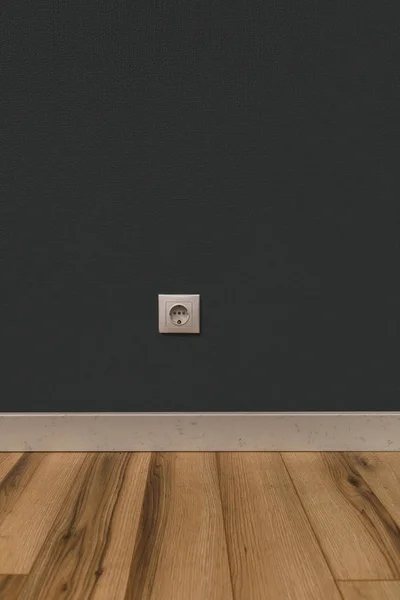 White power socket in wall over wooden floor — Stock Photo