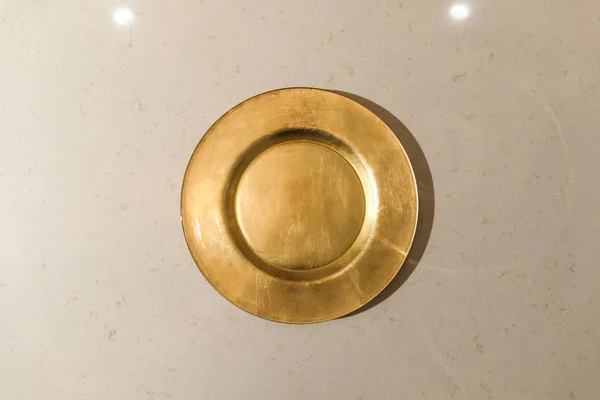 Piastra in metallo dorato su tavolo leggero — Foto stock