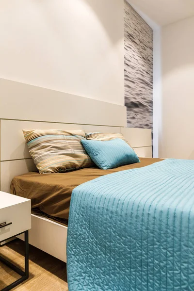 Ropa de cama marrón y azul en la cama en el dormitorio moderno - foto de stock