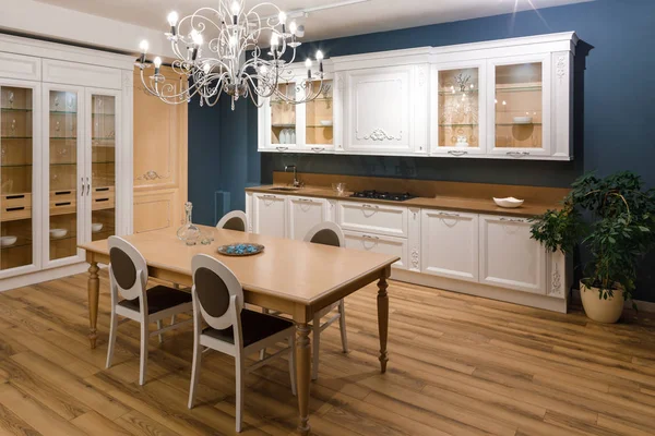 Table with chairs in stylish kitchen with chandelier — Stock Photo