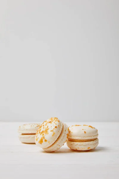 Closeup view of three macarons on white wooden table — Stock Photo