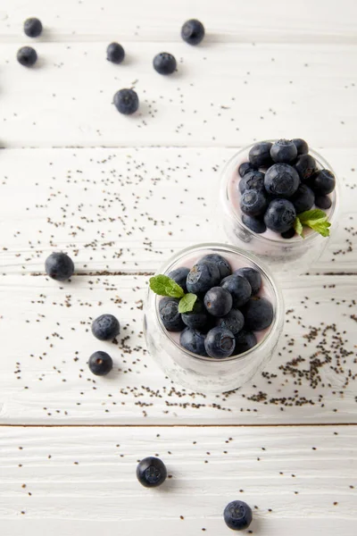 Nahaufnahme von Chiapudding mit frischen Blaubeeren und Minze auf weißer Holzplatte — Stockfoto