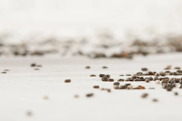 Selective focus of chia seeds on white wooden tabletop — Stock Photo