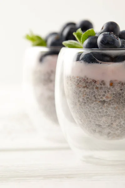 Selective focus of chia puddings with fresh blueberries and mint on surface — Stock Photo