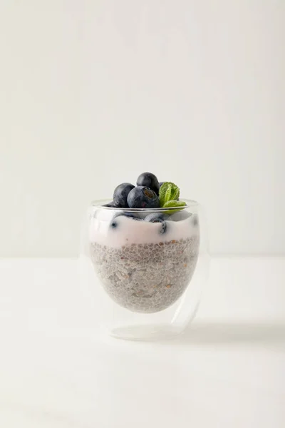 Крупним планом вид на насіння Чіа пудинг з чорницею і м'ятою на білій поверхні — стокове фото