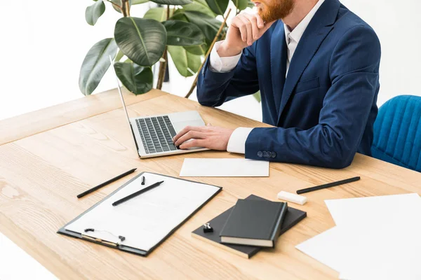 Tiro cortado de homem de negócios trabalhando no laptop no local de trabalho no escritório — Fotografia de Stock