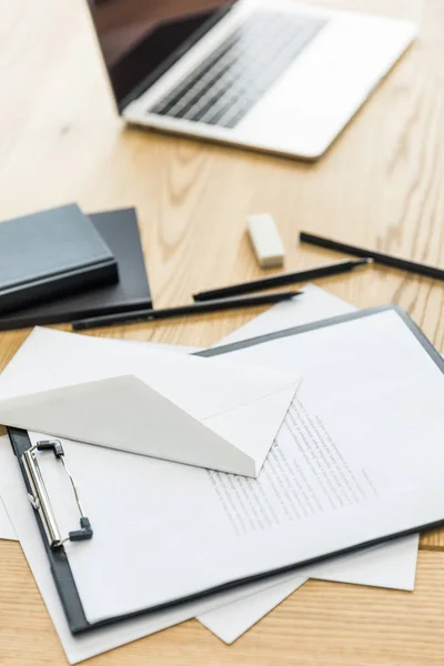 Selective focus of notepad, notebooks and laptop on wooden tabletop — Stock Photo