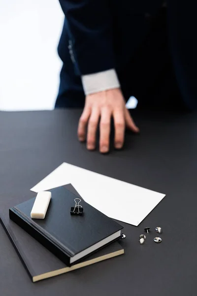 Частичный взгляд бизнесмена в костюме на рабочем месте с ноутбуками, булавками и чистой бумагой — стоковое фото