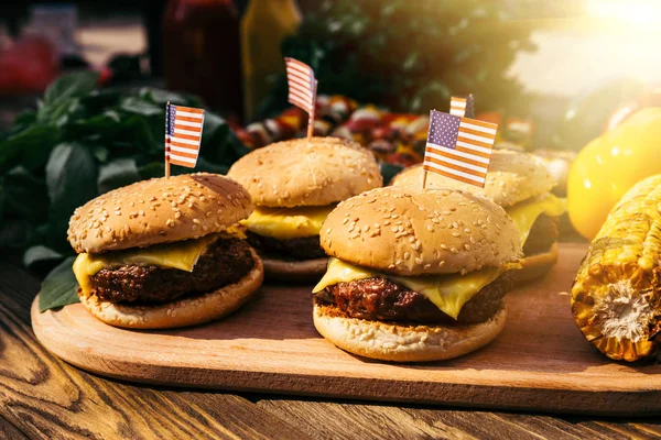 Burgers with us flags grilled for outdoors barbecue — Stock Photo