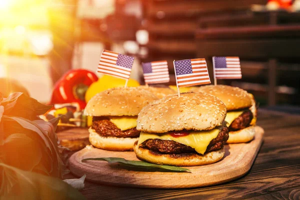 USA flags on hamburgers grilled for outdoors barbecue — Stock Photo