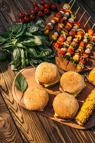 Dinner with hamburgers cooked outdoors on grill — Stock Photo