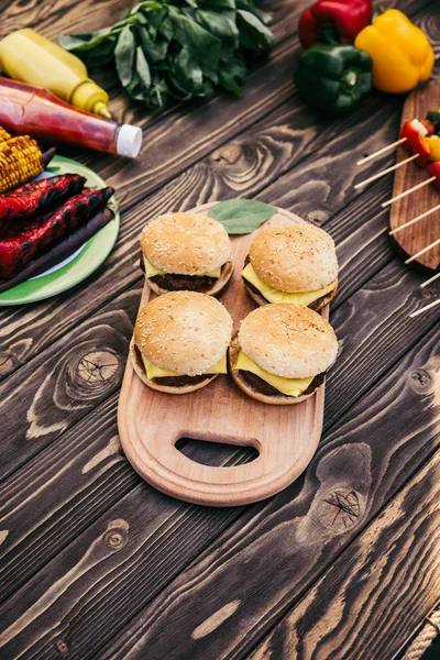 Нарезать овощи и гамбургеры на гриле для барбекю на открытом воздухе — стоковое фото