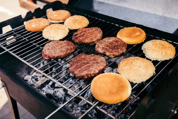Buns and meat patties grilled for outdoors barbecue — Stock Photo
