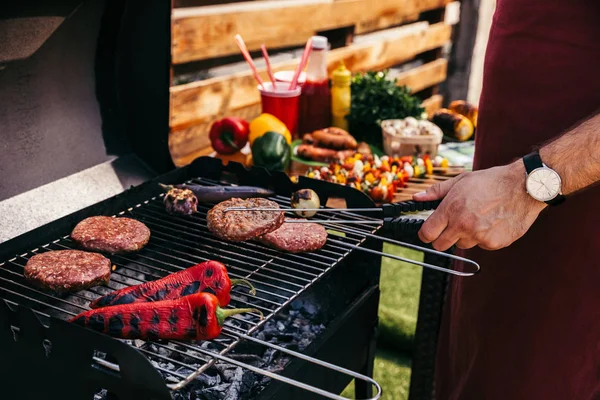 Chef cocinando empanadas y verduras a la parrilla para barbacoa al aire libre - foto de stock