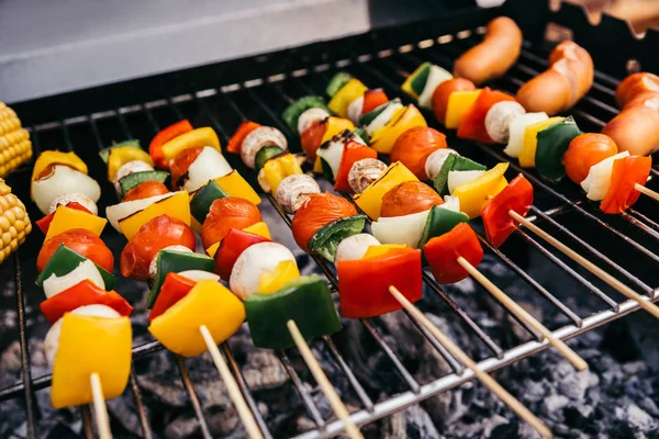 Summer vegetables with mushrooms on skewers and sausages grilled for outdoors barbecue — Stock Photo
