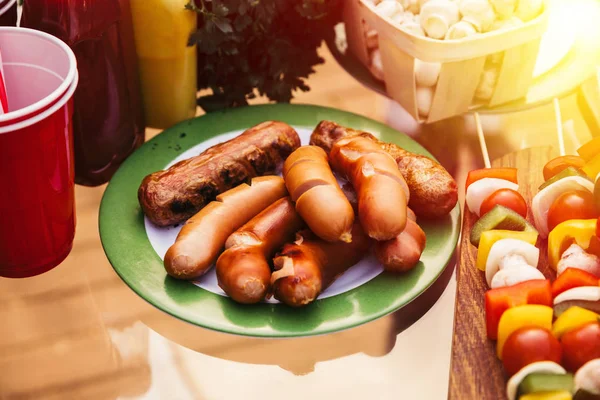 Sausages cooked outdoors on grill served on plate — Stock Photo
