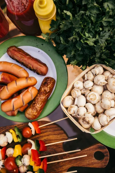 Hot delicious sausages and vegetables with mushrooms cooked outdoors — Stock Photo