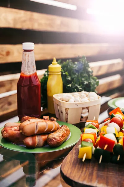 Salsicce calde e verdure con ketchup e senape alla griglia per barbecue all'aperto — Foto stock