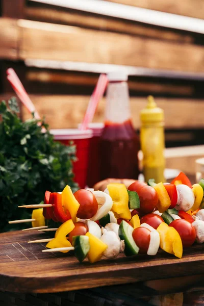 Vegetables on wooden skewers cooked outdoors on table — Stock Photo