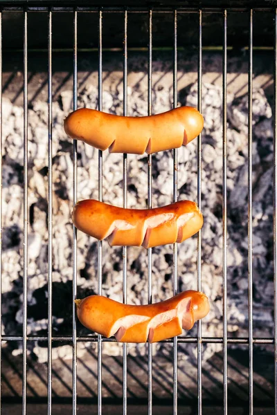 Top view of sausages cooked outdoors on grill — Stock Photo