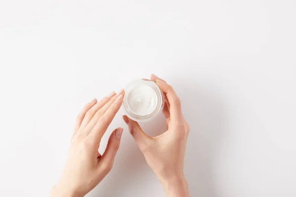 Imagen recortada de la mujer sosteniendo crema orgánica en contenedor - foto de stock