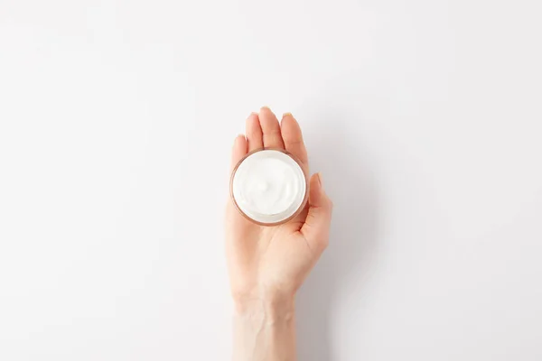 Imagen recortada de la mujer sosteniendo crema orgánica en contenedor - foto de stock