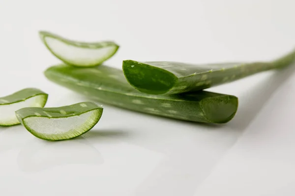 Primo piano colpo di aloe vera foglie fette su superficie bianca — Foto stock