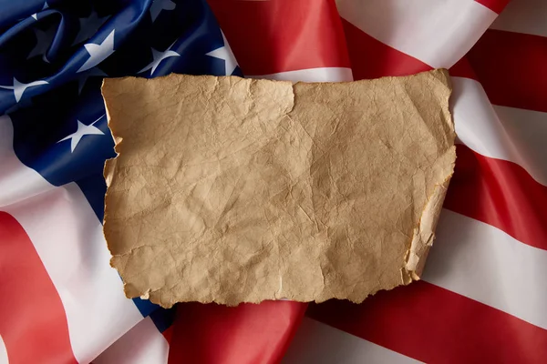 Vue surélevée du papier froissé blanc vintage sur le drapeau américain — Photo de stock