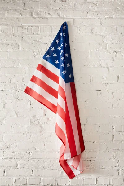 Estados Unidos da América bandeira pendurada na parede de tijolo branco — Fotografia de Stock