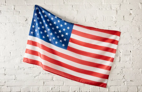 Closeup shot of united states of america flag on white brick wall — Stock Photo