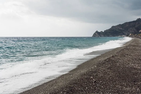 Хвилі бризки моря на піщаному пляжі на узбережжі — стокове фото