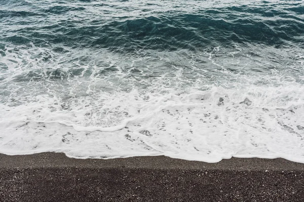 Ondas do mar com espuma branca na praia de areia na costa — Fotografia de Stock