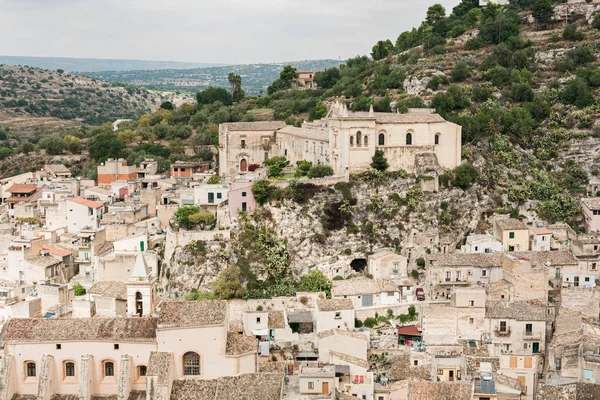 SCICLI, ITALIA - 3 DE OCTUBRE DE 2019: ciudad italiana con casitas cerca de árboles verdes y iglesia de san matteo - foto de stock