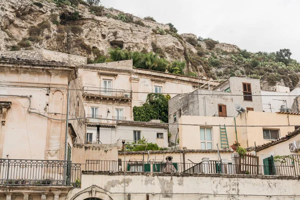 Vecchi piccoli edifici vicino piante verdi in scicly, italia — Foto stock