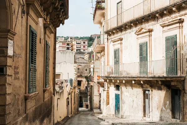 Calle estrecha con casas antiguas en modica, italia - foto de stock