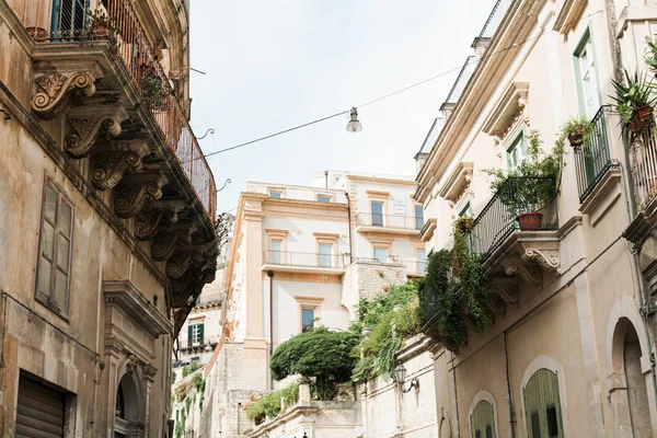 Vista ad angolo basso di piante su balconi di vecchie case in modica, Italia — Foto stock