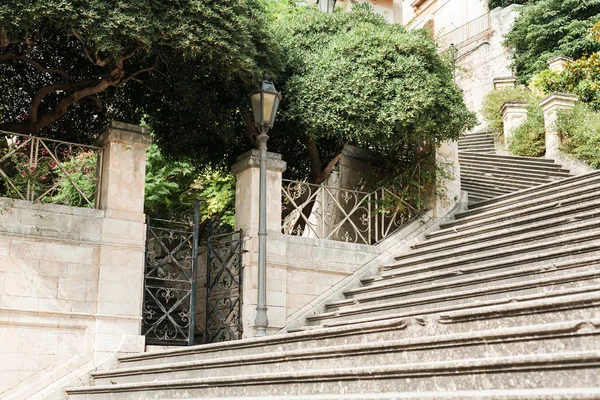 Green trees near stairs and old building in modica, Italy — Stock Photo