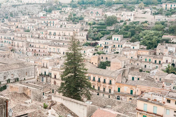 Green trees near ancient buildings in modica, Italy — Stock Photo