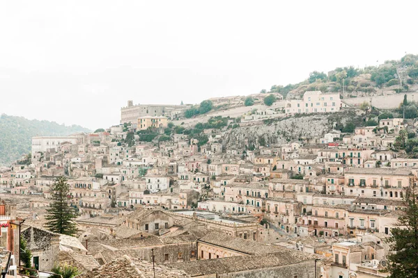 Green trees near ancient buildings against sky in modica, Italy — Stock Photo