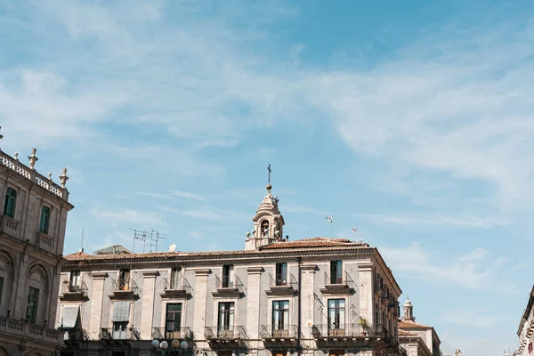 CATANIA, ITALIA - 3 DE OCTUBRE DE 2019: torre del reloj de la catedral de Santa Ágata cerca de edificios antiguos - foto de stock