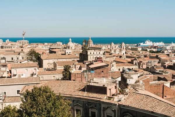 Catania, italien - 3. oktober 2019: sonnenlicht auf der antiken fassade der kathedrale des heiligen agatha in der nähe alter häuser und meeresitalien — Stockfoto