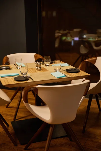 Enfoque selectivo de vasos cerca de los tejidos y cubiertos en la mesa de madera - foto de stock