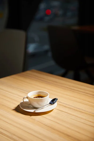 Cup of hot coffee on wooden table in cafe — Stock Photo