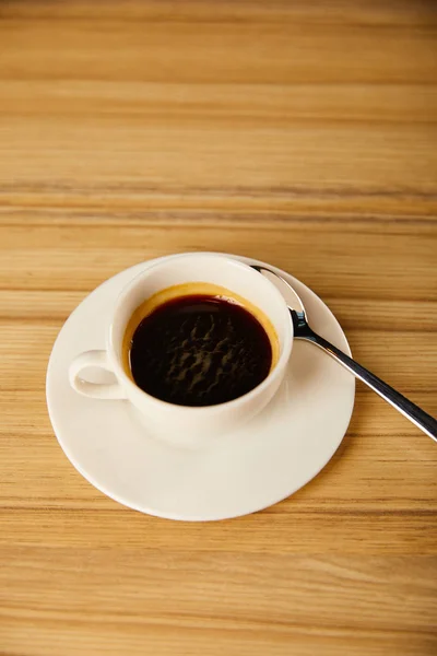 Blick von oben auf weiße Tasse mit Kaffee in der Nähe von Löffel im Café — Stockfoto