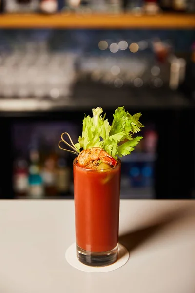 Bloody mary cocktail with celery and shrimp in glass on bar counter — Stock Photo