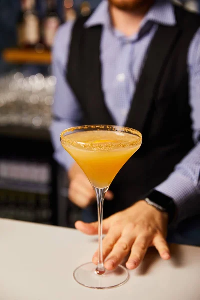 Обрезанный вид бармена, держащего бокал маргариты с холодным коктейлем — стоковое фото